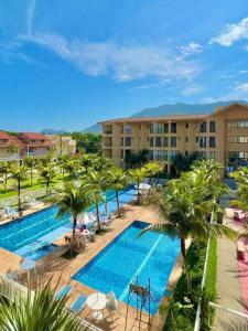 eine Luftaufnahme eines Resort-Pools mit Palmen in der Unterkunft Loft Condado Sahy - Mangaratiba in Mangaratiba