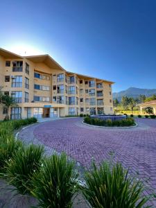 ein großes Mehrfamilienhaus mit einer gemauerten Auffahrt in der Unterkunft Loft Condado Sahy - Mangaratiba in Mangaratiba