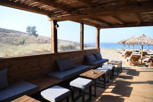 a bar with benches and tables on the beach at Nostos Beachfront Apartments & Studios in Agios Ioannis
