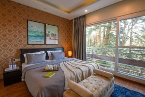 PerfectStayz Shimla في شيملا: غرفة نوم بسرير وكرسي ونافذة