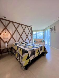 ein Schlafzimmer mit einem großen Bett und einem großen Fenster in der Unterkunft Loft Condado Sahy - Mangaratiba in Mangaratiba