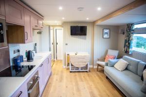 a kitchen with a couch and a living room at Middlemoor Farm Holidays in Alnwick