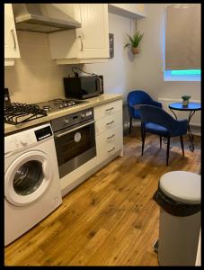 a kitchen with a stove and a washing machine at Redmarley House 