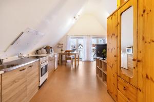 a kitchen with wooden cabinets and a dining room at Hohenzollern in Gammertingen