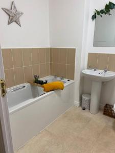 a bathroom with a bath tub and a sink at Redmarley House 