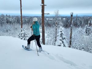 una mujer está parada en los esquís en la nieve en Lehmonkärki Resort en Asikkala