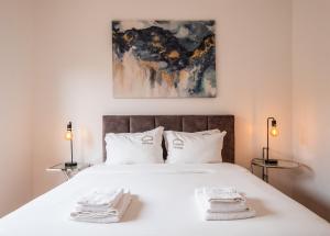 1 dormitorio con 1 cama blanca y 2 toallas en Azores Top House // Luxury and New House en Ponta Delgada