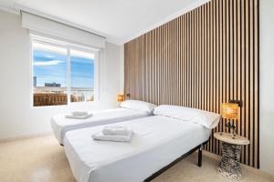 2 łóżka w białym pokoju z oknem w obiekcie Alteanos 16-2 Apartment Levante Beach w mieście Benidorm