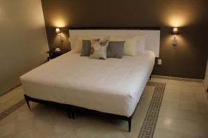 a large white bed with pillows in a bedroom at Entre Patios Hotel Boutique in León