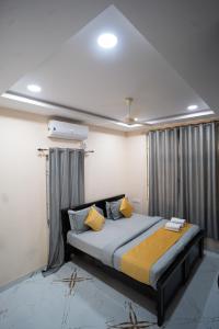 a bedroom with a large bed with yellow pillows at Yellow Bells Gachibowli in Hyderabad