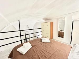 a bedroom with a large bed with two towels on it at Antico Borgo - UN LETTO IDEALE in Gaeta +9 photos