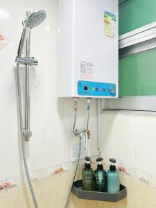 a bathroom with a shower with four bottles on the counter at Student Accommodation - 26 Man Yuen Street in Hong Kong