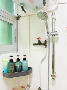 a shower head and a shelf in a bathroom at Student Accommodation - 26 Man Yuen Street in Hong Kong