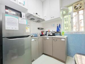 una cocina con nevera de acero inoxidable y armarios en Student Accommodation - 26 Man Yuen Street en Hong Kong