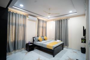 a bedroom with a bed in a room with curtains at Yellow Bells Gachibowli in Hyderabad