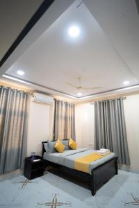 a bedroom with a bed with yellow pillows and curtains at Yellow Bells Gachibowli in Hyderabad