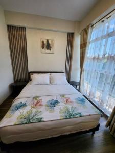 1 dormitorio con 1 cama con colcha de flores en Aloha Ocean Garden Villas Boracay en Boracay