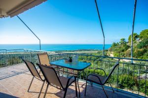 una mesa y sillas en un balcón con vistas al océano en Irida's house en Kefallonia