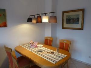 une salle à manger avec une table en bois, des chaises et une lampe dans l'établissement Ferienwohnung 'zimmer Frei', à Gelsenkirchen 9 autres photos