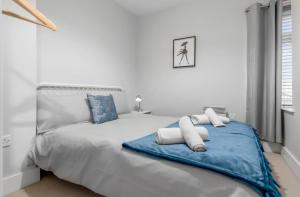 een witte slaapkamer met een groot bed met blauwe en witte kussens bij *NEW* 2 bed apartment on Ber St Norwich in Norwich