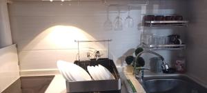 a kitchen counter with a sink and a basket of dishes at 2 Bedroom Condo Unit near Burnham Park by Zoneville Condominiums in Baguio +24 photos