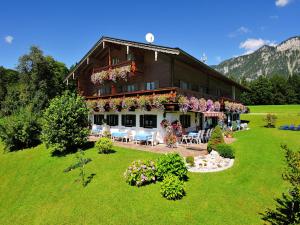 Una casa con flores al costado. en Gästehaus Hillebrand, en Bischofswiesen