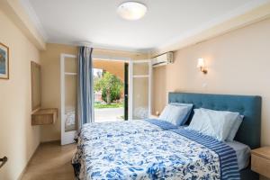 a bedroom with a blue bed and a window at Marietta's Resort by Konnect, Gouvia Corfu in Gouvia