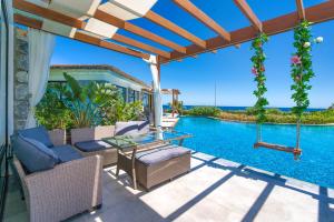 a patio with a glass table and chairs next to a swimming pool at Maldives Holiday Homes in Kyrenia