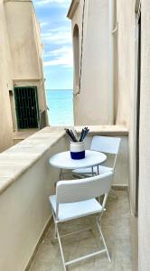a table and two chairs on a balcony with the ocean at Casa Tua - Sea View Chianca in Vieste