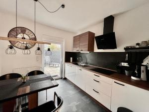 a kitchen with a table and a clock on the wall at - Top Ausstattung - Kostenlos Netflix/Wifi/Parken in Gladbeck