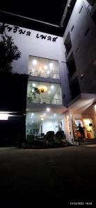 a lit up building with an umbrella in the window at Sukwimol Place in Phitsanulok