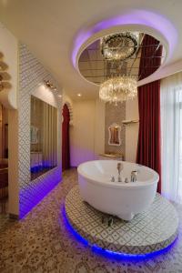 ein großes Bad mit einer Badewanne und einem Kronleuchter in der Unterkunft Sky Star Hotel in Cần Thơ