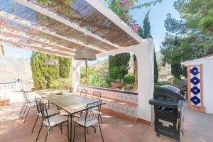 eine Terrasse mit einem Tisch, Stühlen und einem Grill in der Unterkunft Casa Chatsee in Torrox