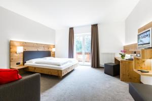 1 dormitorio con 1 cama, TV y sofá en Zur Mühle Wohlfühloase, en Trodena