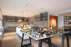 a kitchen with two tables with food on it at Bilderberg Europa Hotel Scheveningen in Scheveningen