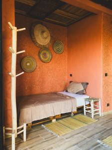 een slaapkamer met een bed en enkele hoeden aan de muur bij Panorama Guesthouse in Agadir