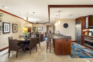 卡波雷的住宿－Ko Olina Beach Villas O1404，厨房以及带桌椅的起居室。