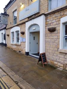 um edifício de tijolos com um sinal em frente em Sanctuary inn em Bolsover