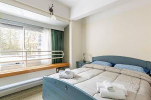 馬里爾伊瓦的住宿－Al centro della Val di Sole，一间卧室设有蓝色的床和窗户。