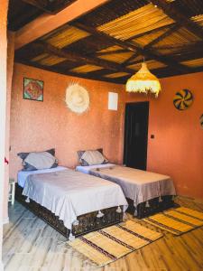 two beds in a room with orange walls at Panorama Guesthouse in Agadir