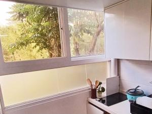 a kitchen with a window above a stove at 2 Bedroom Condo Unit near Burnham Park by Zoneville Condominiums in Baguio