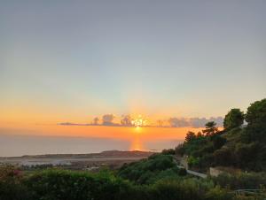 a sunset over the water with the sun in the sky at Irida's house in Kefallonia