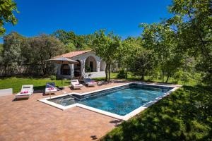 a pool with chairs and an umbrella in a yard at Villa Laura in Medulin for 8 persons only 1.5 km from the beach in Medulin