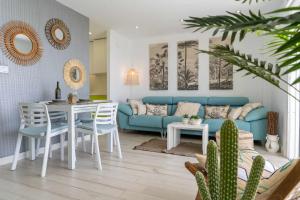 ein Wohnzimmer mit einem blauen Sofa und einem Tisch in der Unterkunft rentafive Nuevo Parking AA Ascensor in Santa Pola