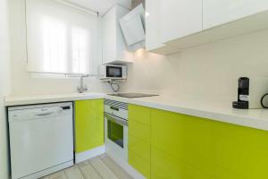 eine Küche mit grünen und weißen Schränken und einer Mikrowelle in der Unterkunft rentafive Nuevo Parking AA Ascensor in Santa Pola