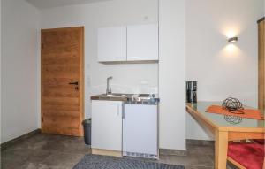eine kleine Küche mit einem Waschbecken und einem Tisch in der Unterkunft Stunning Apartment In Fieberbrunn With Wi-fi in Fieberbrunn