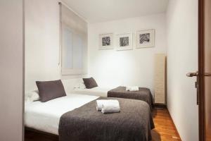 バルセロナにあるCanela Homes BARCELONA UNIVERSITATの白い壁の客室内のベッド2台