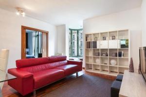 una sala de estar con un sofá rojo en una habitación en Canela Homes BARCELONA UNIVERSITAT, en Barcelona