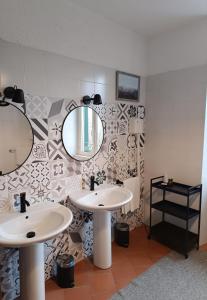 łazienka z 2 umywalkami i lustrem w obiekcie Agriturismo Tenuta la Marchesa w mieście Novi Ligure
