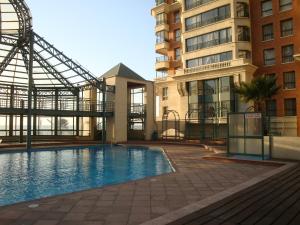 a swimming pool in front of a building at Departamento en Condominio Puerto Pacífico in Viña del Mar